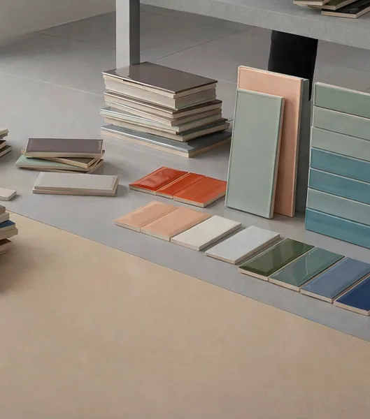 Assorted tile sample boards of different sizes and colours, stacked on a showroom floor