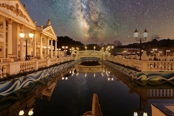 AR Thanga Kottai in Yelagiri lit up at night, its colonnaded palace facade reflected in the pool below under a starry sky