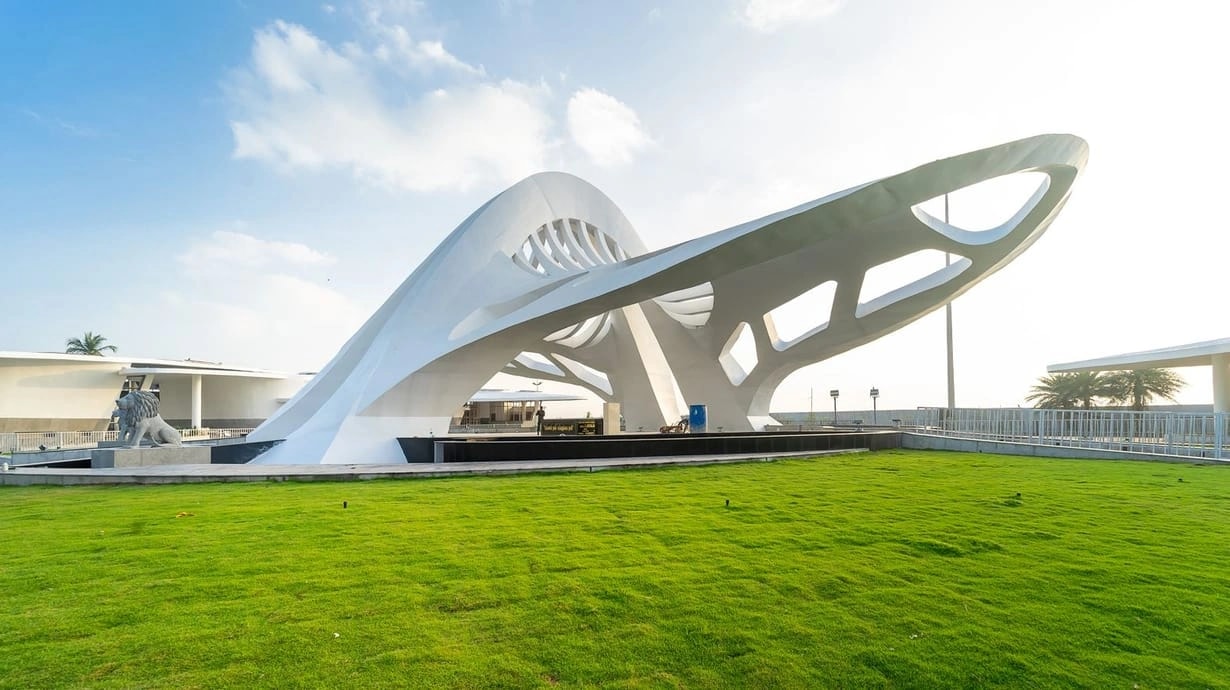 The Jayalalithaa Memorial at Marina Beach, its sweeping white sculptural canopy rising over a lawn beside a lion statue