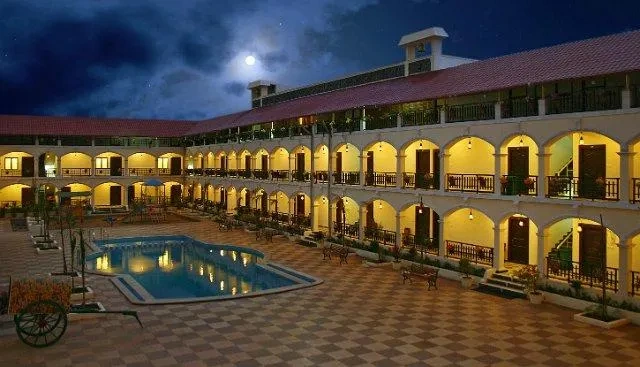 Kumararaja Palace in Yelagiri at dusk, a two-storey arched courtyard hotel wrapped around a lit swimming pool