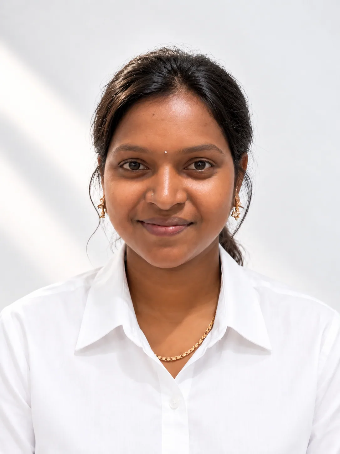 Lavanya, sales executive, in a white shirt against a plain pale grey backdrop
