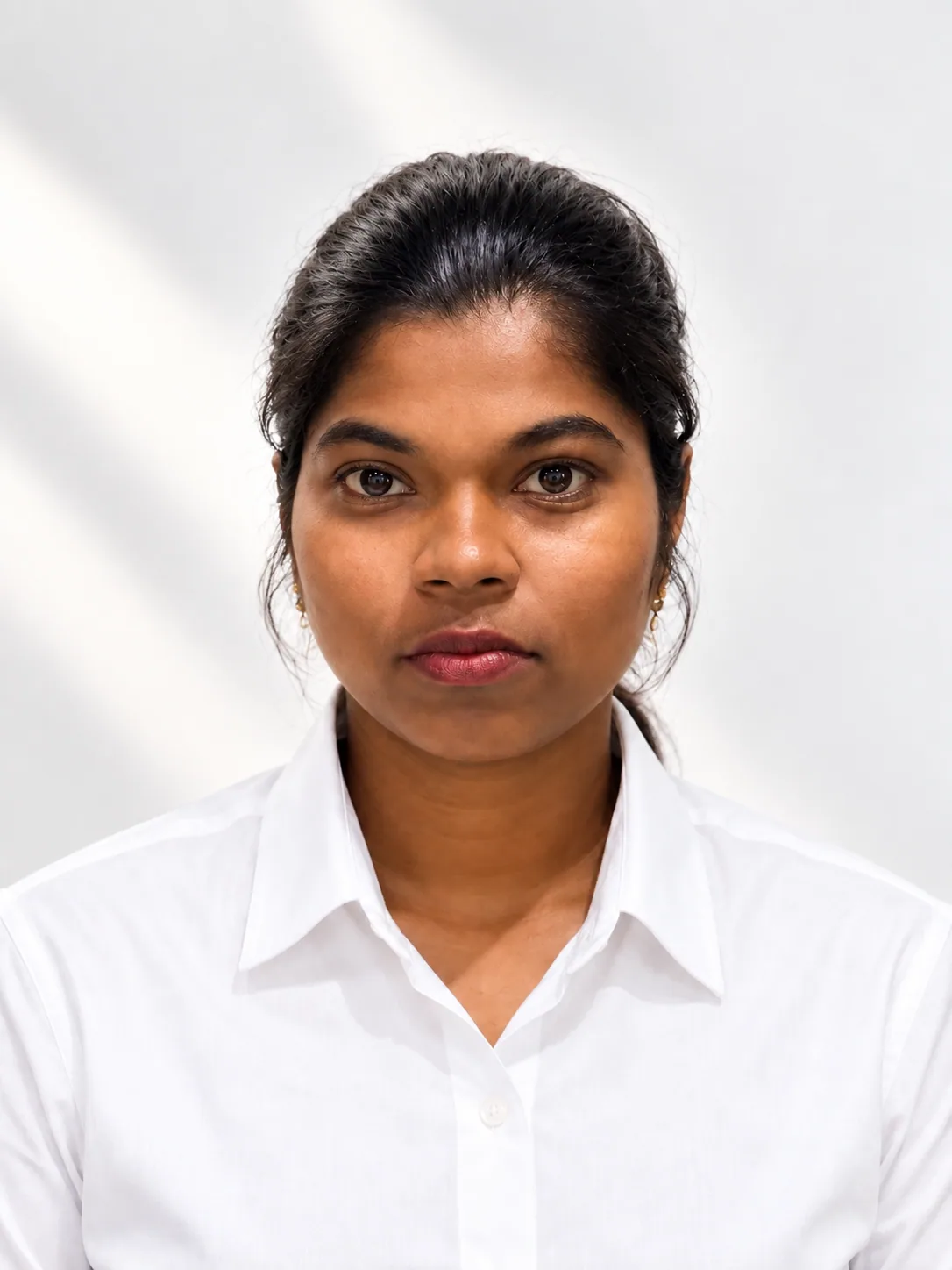 Sindhu, senior sales executive, in a white shirt against a plain pale grey backdrop