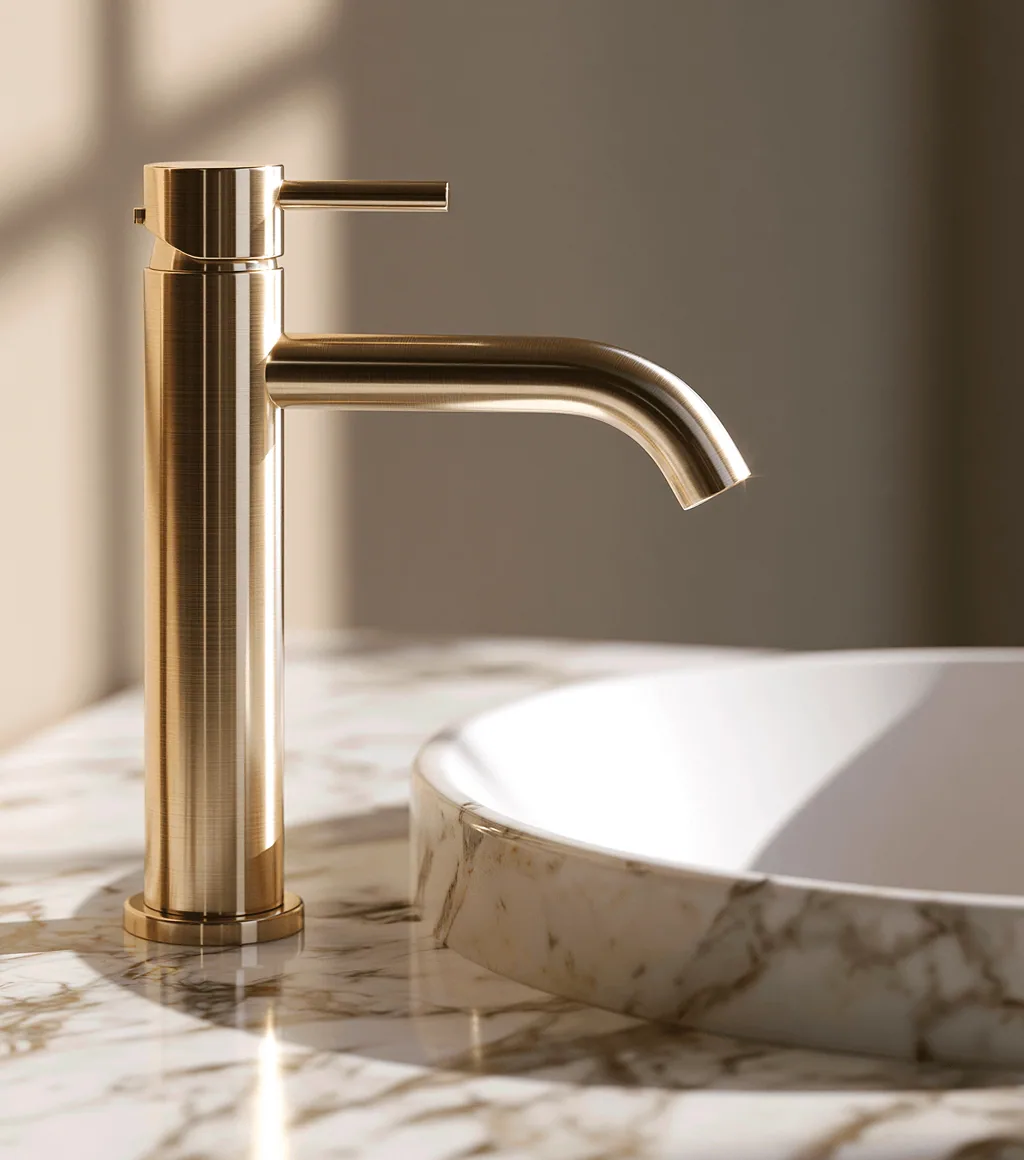 Brushed-gold basin faucet mounted beside a white marble-look vessel basin