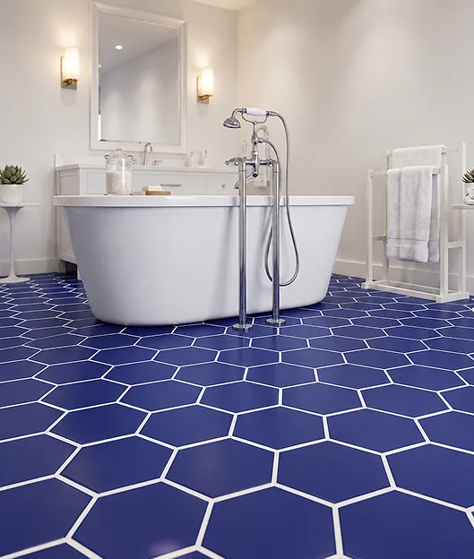 Bathroom with a deep cobalt-blue hexagonal floor tile, beside a freestanding white tub