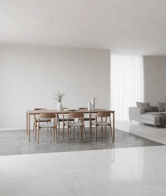 A dining table sits where polished grey marble meets a white marble floor