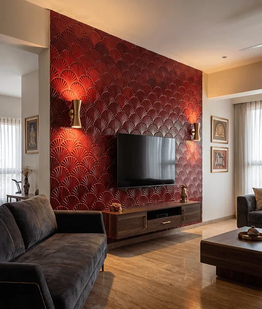 Wall lamps wash a red fan-patterned wall behind the television console