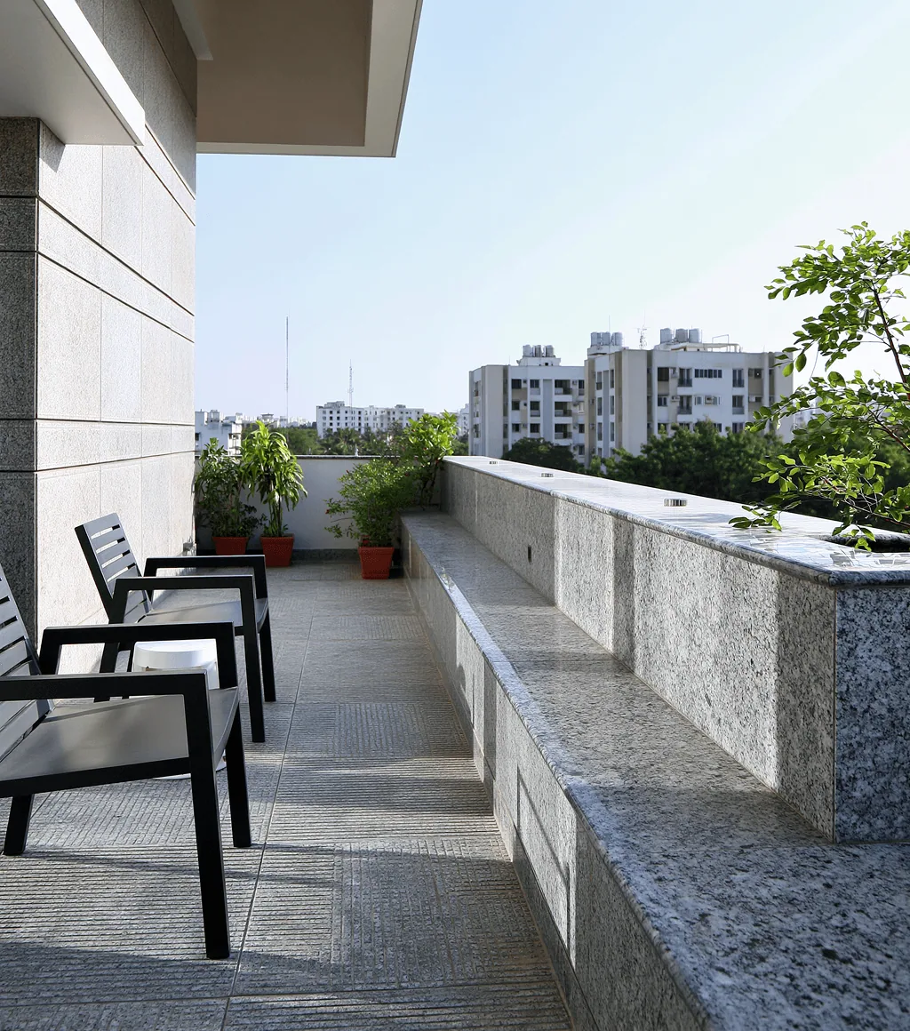 Rooftop terrace parapet capped in polished speckled grey granite