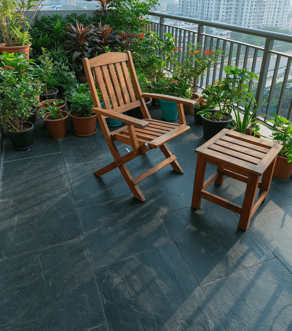 High-rise balcony floored in dark grey-black flamed Kadappa stone, with potted plants