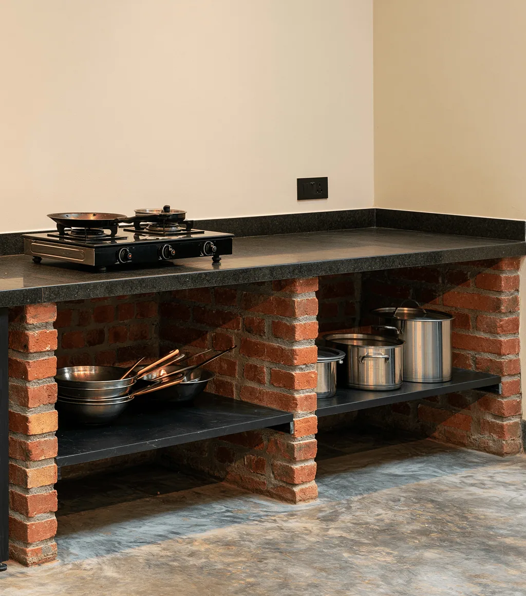 Outdoor kitchen counter with a black flamed-stone worktop over a brick base