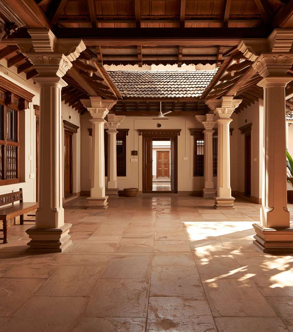 Traditional colonnaded courtyard with a warm beige honed Kota-stone floor and carved wooden pillars