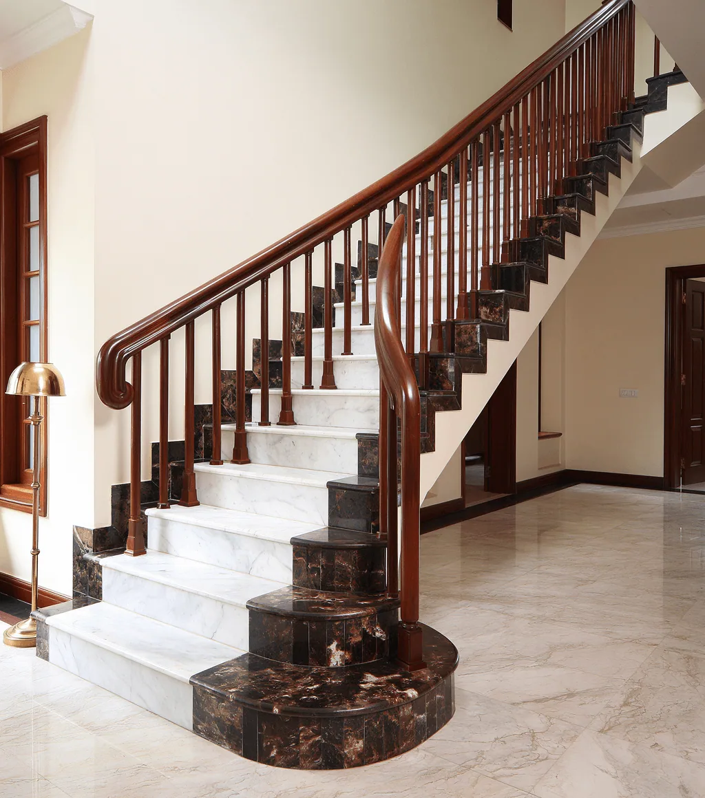 Staircase with white marble treads and dark brown marble risers, beside a timber banister