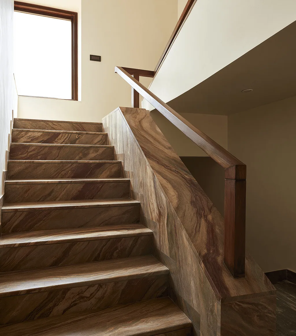 Staircase clad in warm brown quartzite with linear veining