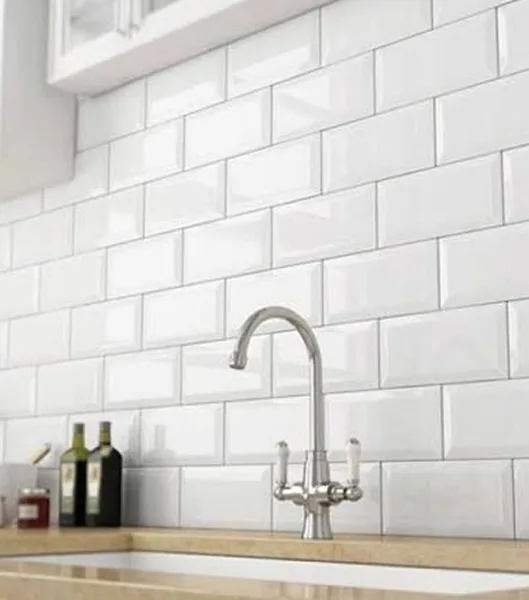 White bevelled subway-tile kitchen backsplash behind a chrome mixer tap