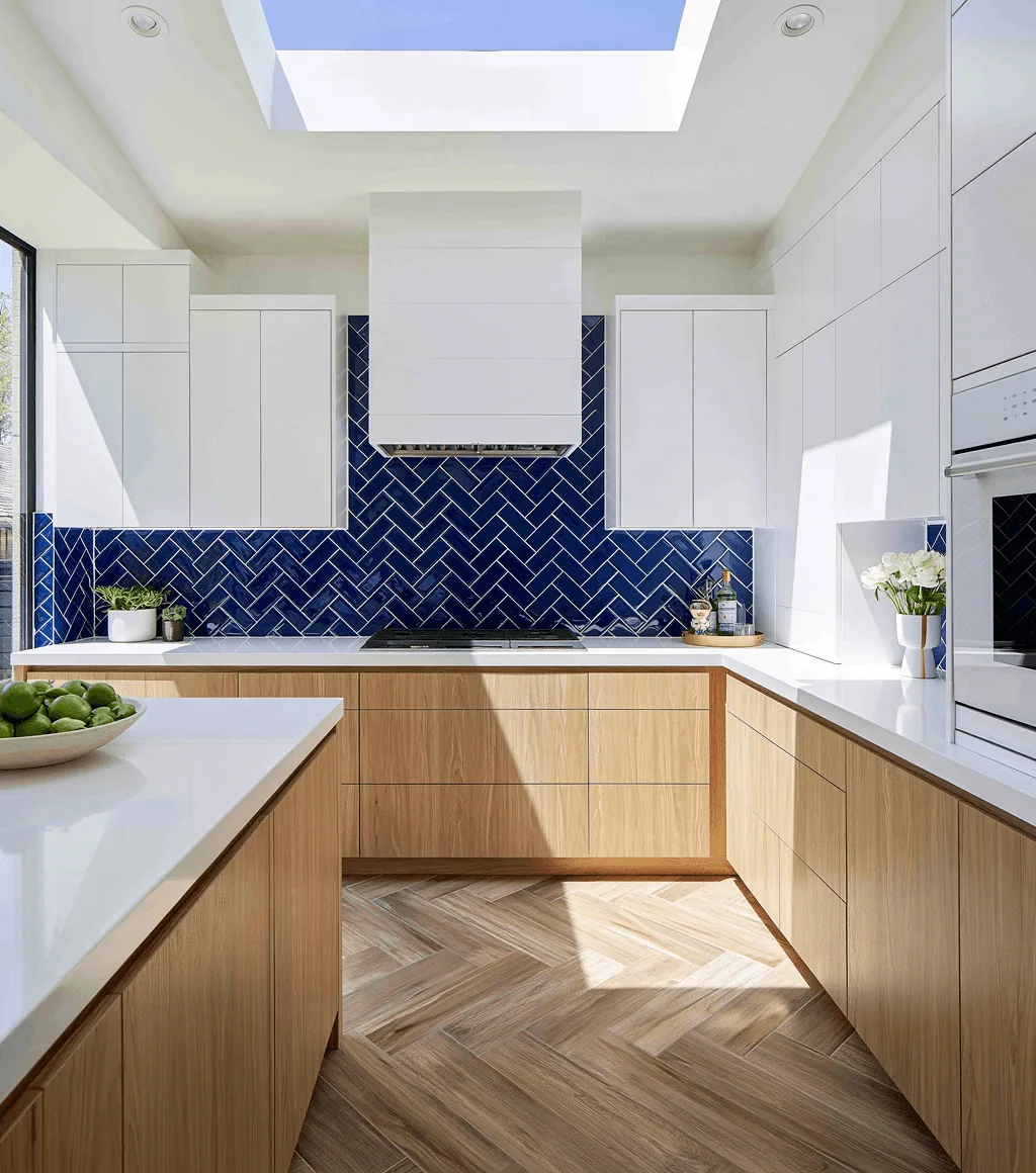 Kitchen with a wood-look herringbone floor tile and a navy-blue herringbone tile backsplash