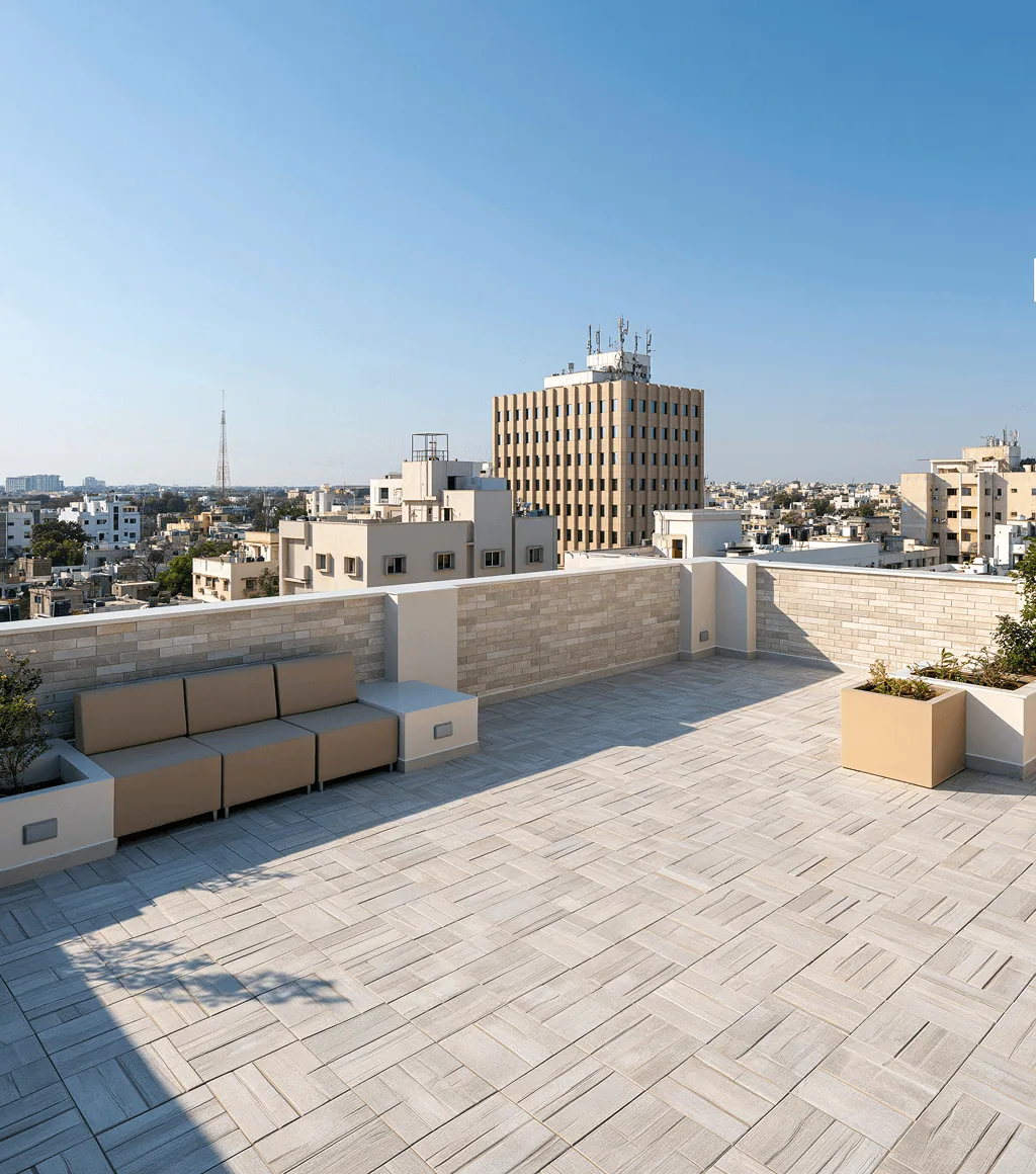 Rooftop terrace in warm grey plank-pattern tile, with a matching stone-clad parapet wall and city skyline