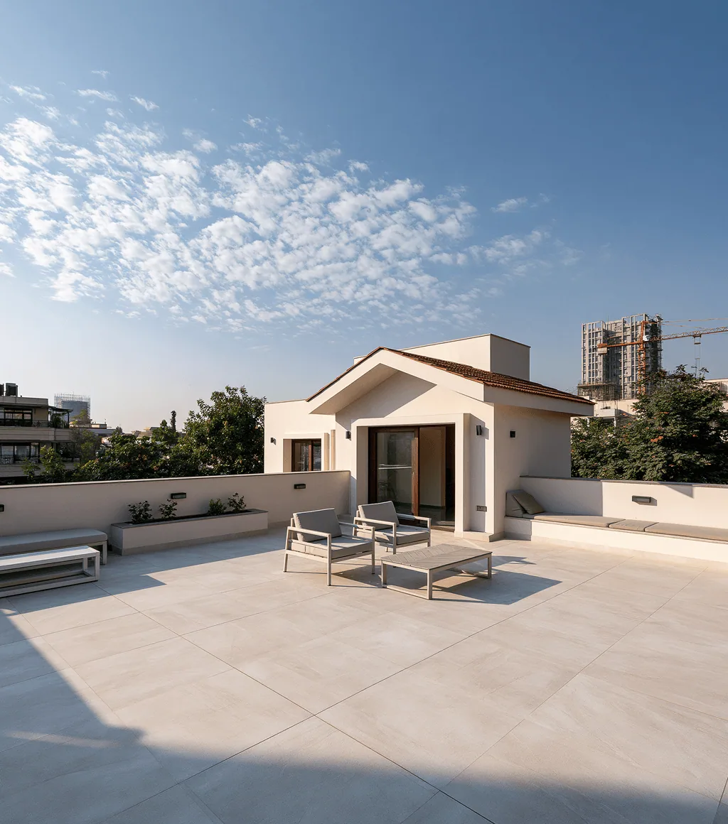 Rooftop terrace in beige large-format stone-look tile, with lounge seating and a city view